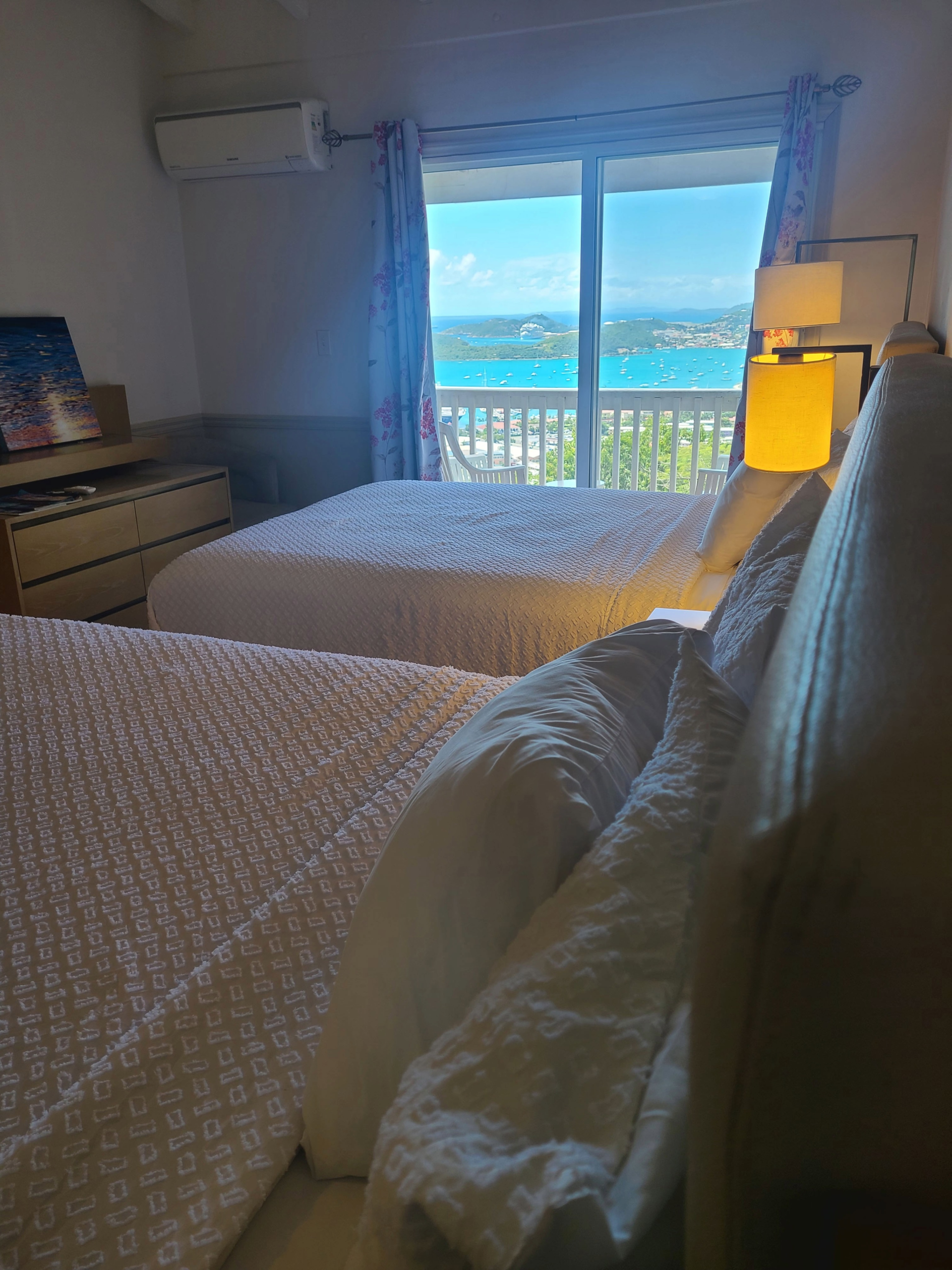 King Deluxe Plus Ocean View room with two beds and a turquoise harbor view balcony