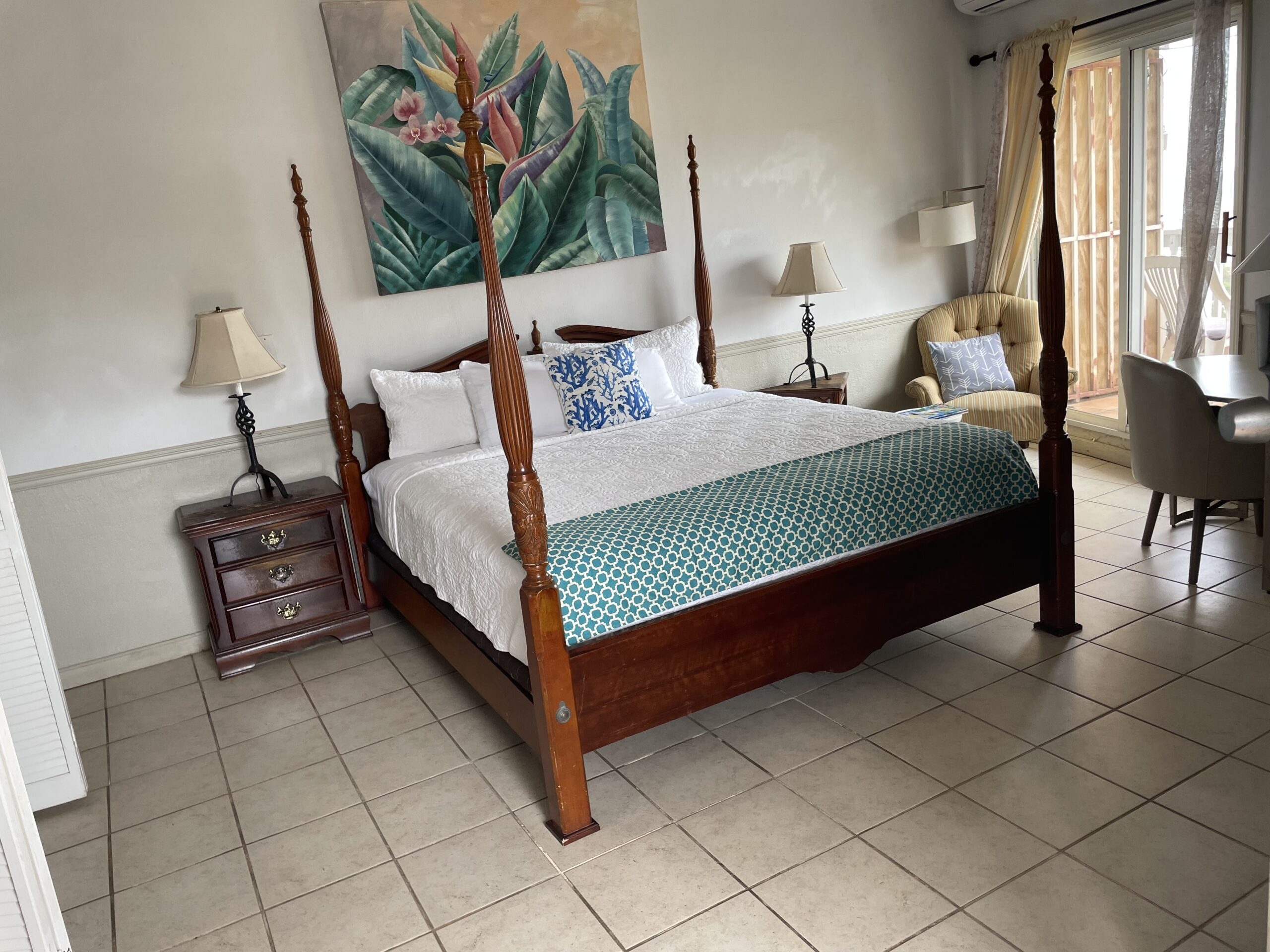 King Deluxe Single Ocean View room with a four-poster bed and tropical art
