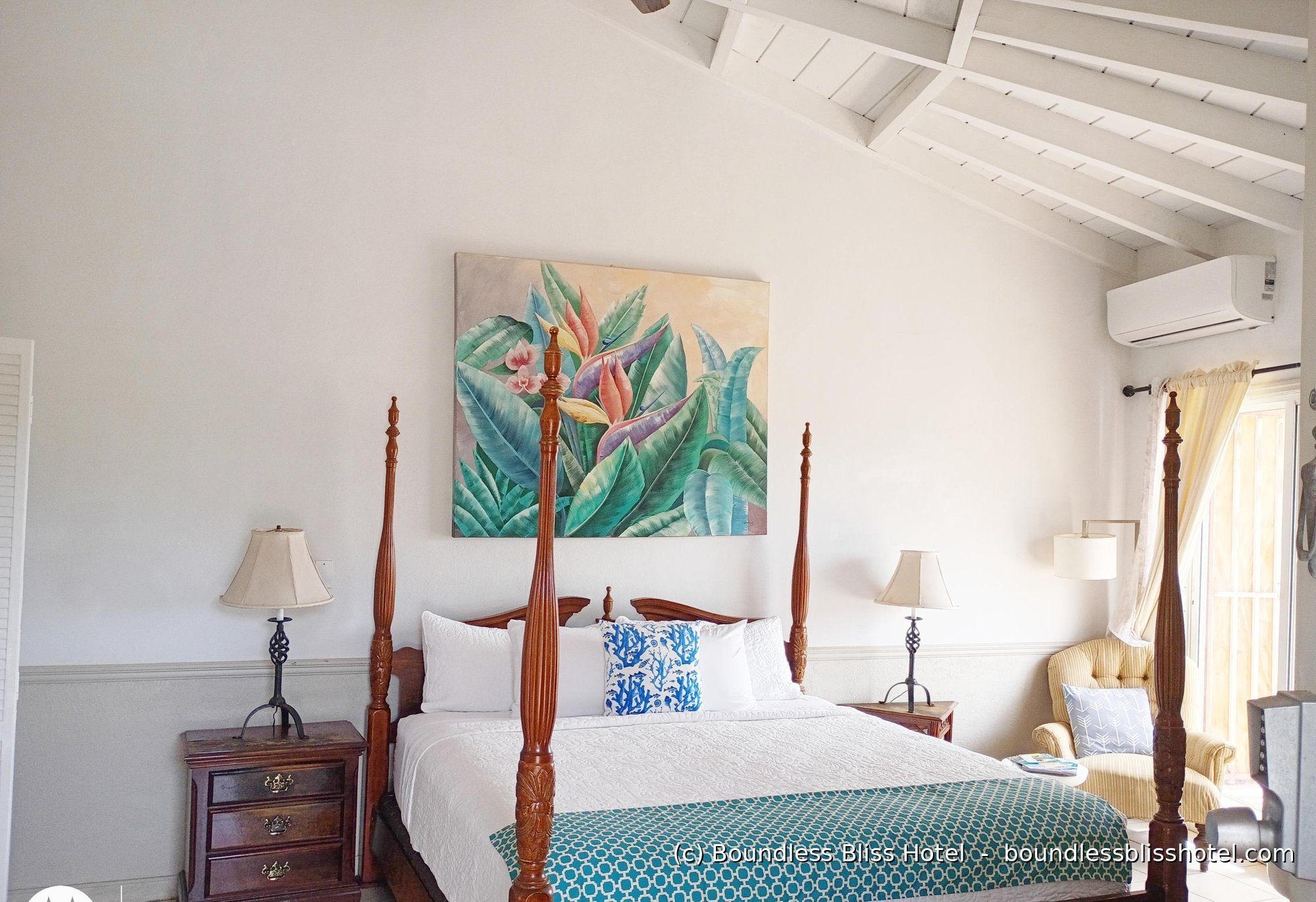Mahogany four-poster king room with tropical art and vaulted beamed ceiling — King Deluxe Single Ocean View, Boundless Bliss Hotel, St. Thomas USVI